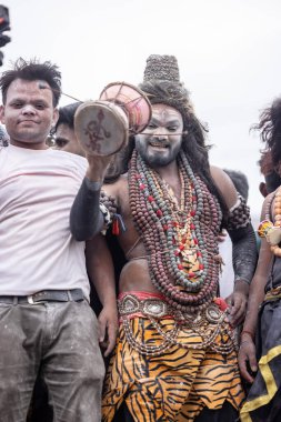 Varanasi, Uttar Pradesh, Hindistan - 20 Mart 2024: Masan Holi, Harishchandra ghat 'ta düzenlenen kutlama sırasında efendi shiva gibi giyinmiş kuru külle boyanmış bir erkek dindar portresi.