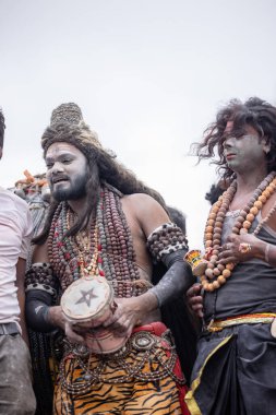 Varanasi, Uttar Pradesh, Hindistan - 20 Mart 2024: Masan Holi, Harishchandra ghat 'ta düzenlenen kutlama sırasında efendi shiva gibi giyinmiş kuru külle boyanmış bir erkek dindar portresi.