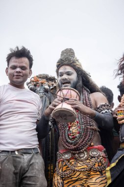 Varanasi, Uttar Pradesh, Hindistan - 20 Mart 2024: Masan Holi, Harishchandra ghat 'ta düzenlenen kutlama sırasında efendi shiva gibi giyinmiş kuru külle boyanmış bir erkek dindar portresi.