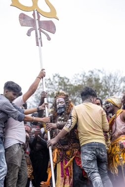 Varanasi, Uttar Pradesh, Hindistan - 20 Mart 2024: Masan Holi, Harishchandra ghat 'ta düzenlenen kutlama sırasında efendi shiva gibi giyinmiş kuru külle boyanmış bir erkek dindar portresi.
