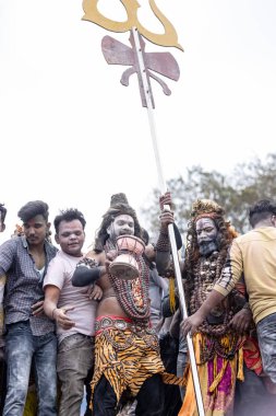 Varanasi, Uttar Pradesh, Hindistan - 20 Mart 2024: Masan Holi, Harishchandra ghat 'ta düzenlenen kutlama sırasında efendi shiva gibi giyinmiş kuru külle boyanmış bir erkek dindar portresi.