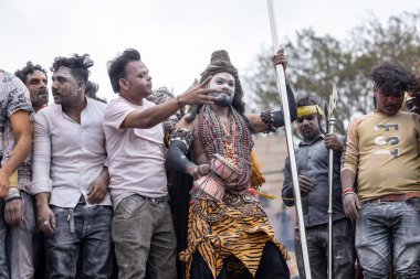 Varanasi, Uttar Pradesh, Hindistan - 20 Mart 2024: Masan Holi, Harishchandra ghat 'ta düzenlenen kutlama sırasında efendi shiva gibi giyinmiş kuru külle boyanmış bir erkek dindar portresi.