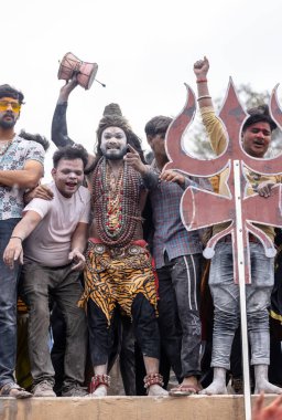 Varanasi, Uttar Pradesh, Hindistan - 20 Mart 2024: Masan Holi, Harishchandra ghat 'ta düzenlenen kutlama sırasında efendi shiva gibi giyinmiş kuru külle boyanmış bir erkek dindar portresi.