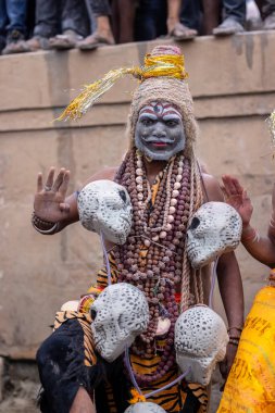 Varanasi, Uttar Pradesh, Hindistan - 20 Mart 2024: Masan Holi, Harishchandra ghat 'ta düzenlenen kutlama sırasında efendi shiva gibi giyinmiş kuru külle boyanmış bir erkek dindar portresi.