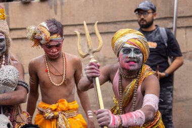 Varanasi, Uttar Pradesh, Hindistan - 20 Mart 2024: Masan Holi, Harishchandra ghat 'ta düzenlenen kutlama sırasında efendi shiva gibi giyinmiş kuru külle boyanmış bir erkek dindar portresi.