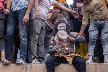 Varanasi, Uttar Pradesh, Hindistan - 20 Mart 2024: Masan Holi, Harishchandra ghat 'ta düzenlenen kutlama sırasında efendi shiva gibi giyinmiş kuru külle boyanmış bir erkek dindar portresi.