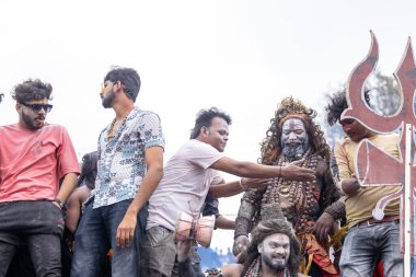 Varanasi, Uttar Pradesh, Hindistan - 20 Mart 2024: Masan Holi, Harishchandra ghat 'ta düzenlenen kutlama sırasında efendi shiva gibi giyinmiş kuru külle boyanmış bir erkek dindar portresi.