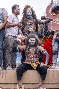 Varanasi, Uttar Pradesh, Hindistan - 20 Mart 2024: Masan Holi, Harishchandra ghat 'ta düzenlenen kutlama sırasında efendi shiva gibi giyinmiş kuru külle boyanmış bir erkek dindar portresi.