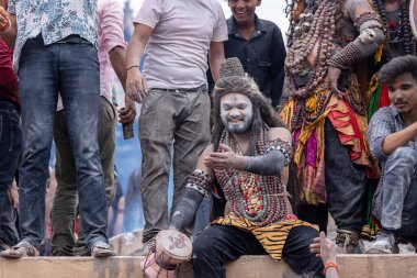 Varanasi, Uttar Pradesh, Hindistan - 20 Mart 2024: Masan Holi, Harishchandra ghat 'ta düzenlenen kutlama sırasında efendi shiva gibi giyinmiş kuru külle boyanmış bir erkek dindar portresi.