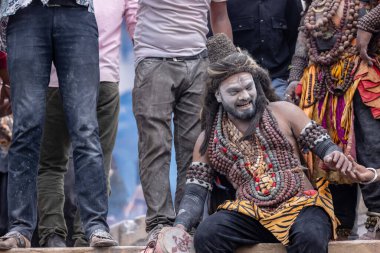 Varanasi, Uttar Pradesh, Hindistan - 20 Mart 2024: Masan Holi, Harishchandra ghat 'ta düzenlenen kutlama sırasında efendi shiva gibi giyinmiş kuru külle boyanmış bir erkek dindar portresi.