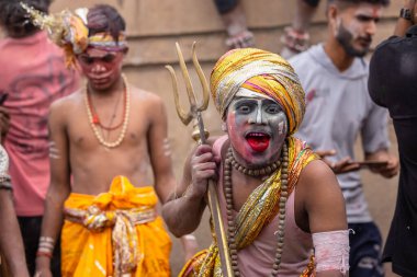 Varanasi, Uttar Pradesh, Hindistan - 20 Mart 2024: Masan Holi, Harishchandra ghat 'ta düzenlenen kutlama sırasında efendi shiva gibi giyinmiş kuru külle boyanmış bir erkek dindar portresi.
