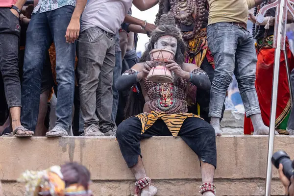Varanasi, Uttar Pradesh, Hindistan - 20 Mart 2024: Masan Holi, Harishchandra ghat 'ta düzenlenen kutlama sırasında efendi shiva gibi giyinmiş kuru külle boyanmış bir erkek dindar portresi.