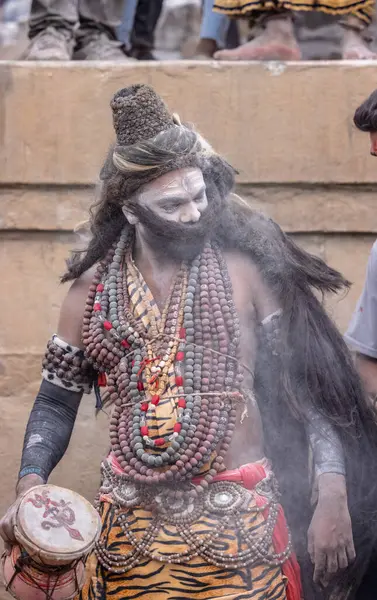 Varanasi, Uttar Pradesh, Hindistan - 20 Mart 2024: Masan Holi, Harishchandra ghat 'ta düzenlenen kutlama sırasında efendi shiva gibi giyinmiş kuru külle boyanmış bir erkek dindar portresi.