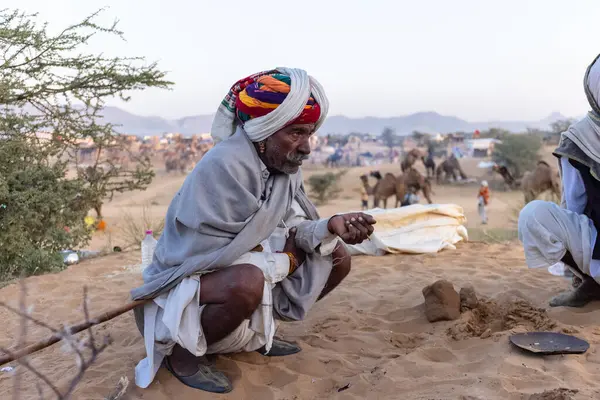 Bikaner, Rajasthan, Hindistan - 15 Ocak 2023: Siluet konsepti, gökyüzünün altındaki tepelerin tepesinde duran develer. Kimliği belirlenemeyen kişi.