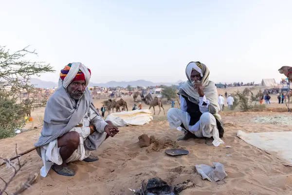 Bikaner, Rajasthan, Hindistan - 15 Ocak 2023: Siluet konsepti, gökyüzünün altındaki tepelerin tepesinde duran develer. Kimliği belirlenemeyen kişi.