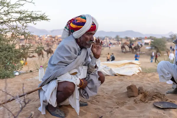 Bikaner, Rajasthan, Hindistan - 15 Ocak 2023: Siluet konsepti, gökyüzünün altındaki tepelerin tepesinde duran develer. Kimliği belirlenemeyen kişi.