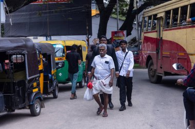 Thiruvananthapuram, Kerala, Hindistan - 14 Ekim 2024: Sokak fotoğrafçılığı, Insanlar Hindistan 'ın güneyinde Kerala sokaklarında geleneksel kıyafetlerle farklı ulaşım şekillerini kullanıyorlar..