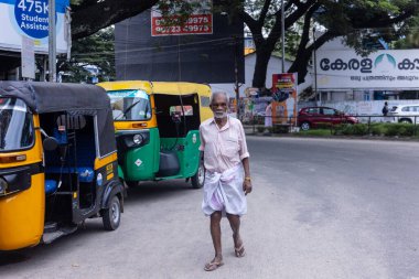 Thiruvananthapuram, Kerala, Hindistan - 14 Ekim 2024: Sokak fotoğrafçılığı, Insanlar Hindistan 'ın güneyinde Kerala sokaklarında geleneksel kıyafetlerle farklı ulaşım şekillerini kullanıyorlar..