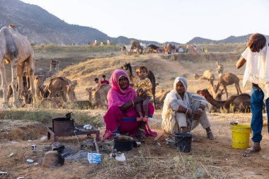 Puşkar, Rajasthan, Hindistan - Kasım 09 2024: Geleneksel giysili bir rajasthani erkek portresi çöl panayırında develerin ticareti sırasında türbanlı..