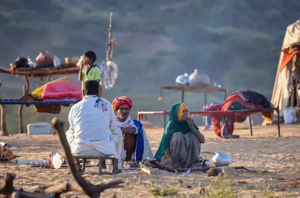 Puşkar, Rajasthan, Hindistan - Kasım 09 2024: Geleneksel beyaz giysili rajasthani erkek portresi çöl panayırında deve fuarı sırasında deve ticareti sırasında sarıklı.
