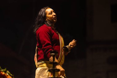 Varanasi, Uttar Pradesh, Hindistan - 20 Ocak 2024: Ganga aarti, Dashashwamedh ghat geleneksel elbise ve Hindu ayinleri ile kutsal nehir keneviri akşam ayini yapan genç bir rahibin portresi.