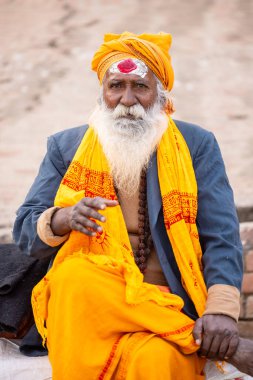 Varanasi, Uttar Pradesh, Hindistan - 20 Ocak 2024: Varanasi 'deki çetelerin yakınındaki ghatlarda oturan geleneksel bir sadhu baba resmi. Sadhu, Kaşhi 'de Ganga yakınlarında ayinler düzenler..
