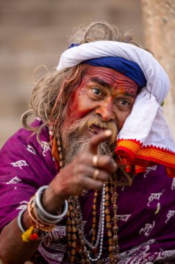 Varanasi, Uttar Pradesh, Hindistan - 20 Ocak 2024: Varanasi 'deki çetelerin yakınındaki ghatlarda oturan geleneksel bir sadhu baba resmi. Sadhu, Kaşhi 'de Ganga yakınlarında ayinler düzenler..