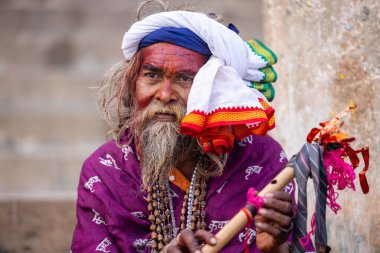 Varanasi, Uttar Pradesh, Hindistan - 20 Ocak 2024: Varanasi 'deki çetelerin yakınındaki ghatlarda oturan geleneksel bir sadhu baba resmi. Sadhu, Kaşhi 'de Ganga yakınlarında ayinler düzenler..