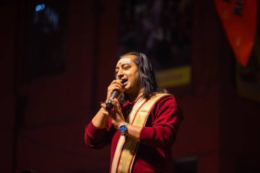 Varanasi, Uttar Pradesh, Hindistan - 20 Ocak 2024: Ganga aarti, Dashashwamedh ghat geleneksel elbise ve Hindu ayinleri ile kutsal nehir keneviri akşam ayini yapan genç bir rahibin portresi.