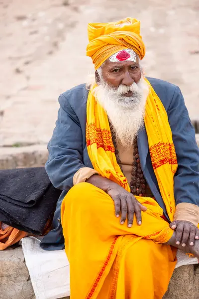 Varanasi, Uttar Pradesh, Hindistan - 20 Ocak 2024: Varanasi 'deki çetelerin yakınındaki ghatlarda oturan geleneksel bir sadhu baba resmi. Sadhu, Kaşhi 'de Ganga yakınlarında ayinler düzenler..