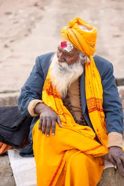 Varanasi, Uttar Pradesh, Hindistan - 20 Ocak 2024: Varanasi 'deki çetelerin yakınındaki ghatlarda oturan geleneksel bir sadhu baba resmi. Sadhu, Kaşhi 'de Ganga yakınlarında ayinler düzenler..