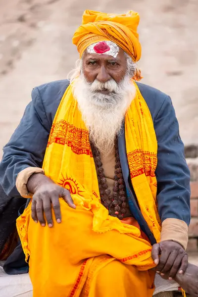 Varanasi, Uttar Pradesh, Hindistan - 20 Ocak 2024: Varanasi 'deki çetelerin yakınındaki ghatlarda oturan geleneksel bir sadhu baba resmi. Sadhu, Kaşhi 'de Ganga yakınlarında ayinler düzenler..