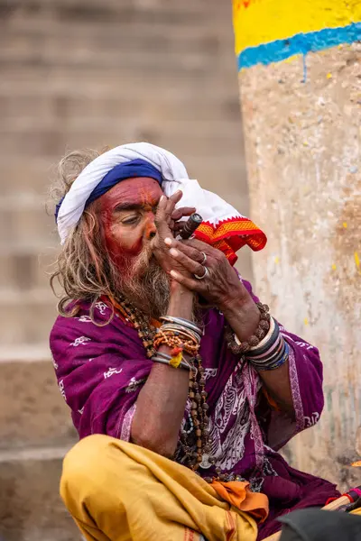 Varanasi, Uttar Pradesh, Hindistan - 20 Ocak 2024: Varanasi 'deki çetelerin yakınındaki ghatlarda oturan geleneksel bir sadhu baba resmi. Sadhu, Kaşhi 'de Ganga yakınlarında ayinler düzenler..