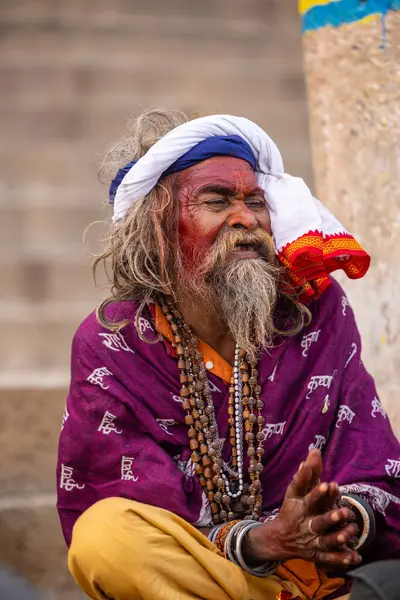 Varanasi, Uttar Pradesh, Hindistan - 20 Ocak 2024: Varanasi 'deki çetelerin yakınındaki ghatlarda oturan geleneksel bir sadhu baba resmi. Sadhu, Kaşhi 'de Ganga yakınlarında ayinler düzenler..