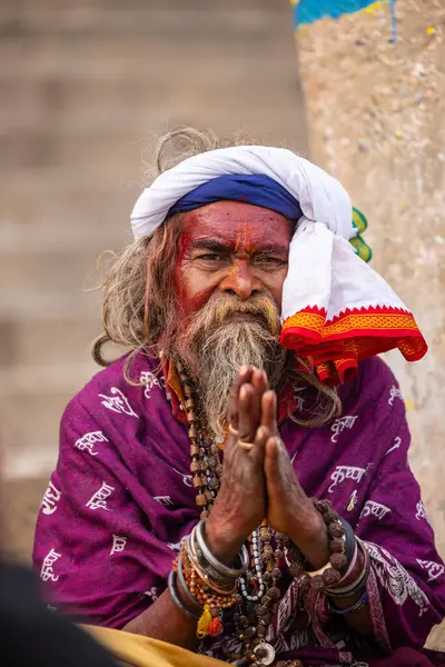 Varanasi, Uttar Pradesh, Hindistan - 20 Ocak 2024: Varanasi 'deki çetelerin yakınındaki ghatlarda oturan geleneksel bir sadhu baba resmi. Sadhu, Kaşhi 'de Ganga yakınlarında ayinler düzenler..