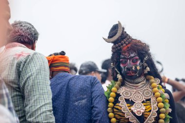 Varanasi, Uttar Pradesh, Hindistan - 20 Mart 2024: Masan Holi, Harishchandra ghat 'ta düzenlenen kutlama sırasında Lord Shiva kılığında kuru külle boyanmış insanların portresi.