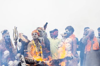 Varanasi, Uttar Pradesh, Hindistan - 20 Mart 2024: Masan Holi, Harishchandra ghat 'ta düzenlenen kutlama sırasında Lord Shiva kılığında kuru külle boyanmış insanların portresi.