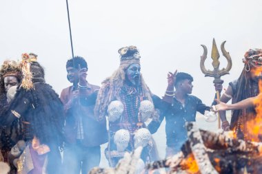 Varanasi, Uttar Pradesh, Hindistan - 20 Mart 2024: Masan Holi, Harishchandra ghat 'ta düzenlenen kutlama sırasında Lord Shiva kılığında kuru külle boyanmış insanların portresi.
