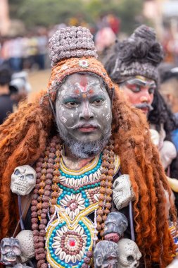 Varanasi, Uttar Pradesh, Hindistan - 20 Mart 2024: Masan Holi, Harishchandra ghat 'ta düzenlenen kutlama sırasında efendi shiva gibi giyinmiş kuru külle boyanmış bir erkek dindar portresi.
