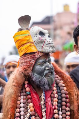 Varanasi, Uttar Pradesh, Hindistan - 20 Mart 2024: Masan Holi, Harishchandra ghat 'ta düzenlenen kutlama sırasında efendi shiva gibi giyinmiş kuru külle boyanmış bir erkek dindar portresi.