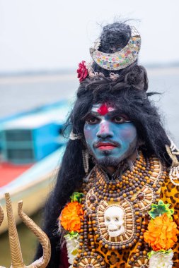 Varanasi, Uttar Pradesh, Hindistan - 20 Mart 2024: Masan Holi, Harishchandra ghat 'ta düzenlenen kutlama sırasında Lord Shiva kılığında kuru külle boyanmış insanların portresi.