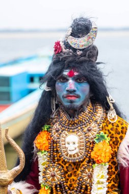 Varanasi, Uttar Pradesh, Hindistan - 20 Mart 2024: Masan Holi, Harishchandra ghat 'ta düzenlenen kutlama sırasında Lord Shiva kılığında kuru külle boyanmış insanların portresi.