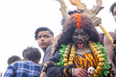 Varanasi, Uttar Pradesh, Hindistan - 20 Mart 2024: Masan Holi, Harishchandra ghat 'ta düzenlenen kutlama sırasında Lord Shiva gibi giyinmiş kuru külle boyanmış yüzlü insanların portresi.