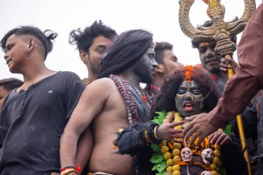 Varanasi, Uttar Pradesh, Hindistan - 20 Mart 2024: Masan Holi, Harishchandra ghat 'ta düzenlenen kutlama sırasında Lord Shiva gibi giyinmiş kuru külle boyanmış yüzlü insanların portresi.