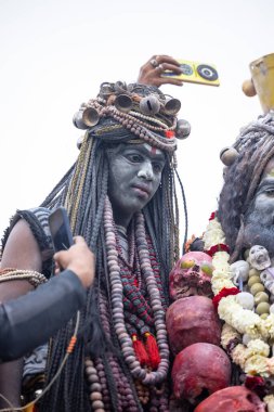 Varanasi, Uttar Pradesh, Hindistan - 20 Mart 2024: Masan Holi, Harishchandra ghat 'ta düzenlenen kutlama sırasında Lord Shiva gibi giyinmiş kuru külle boyanmış yüzlü insanların portresi.