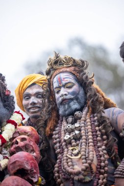 Varanasi, Uttar Pradesh, Hindistan - 20 Mart 2024: Masan Holi, Harishchandra ghat 'ta düzenlenen kutlama sırasında Lord Shiva gibi giyinmiş kuru külle boyanmış yüzlü insanların portresi.