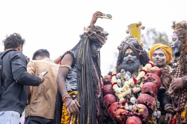 Varanasi, Uttar Pradesh, Hindistan - 20 Mart 2024: Masan Holi, Harishchandra ghat 'ta düzenlenen kutlama sırasında Lord Shiva gibi giyinmiş kuru külle boyanmış yüzlü insanların portresi.