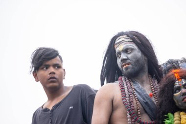 Varanasi, Uttar Pradesh, Hindistan - 20 Mart 2024: Masan Holi, Harishchandra ghat 'ta düzenlenen kutlama sırasında Lord Shiva gibi giyinmiş kuru külle boyanmış yüzlü insanların portresi.