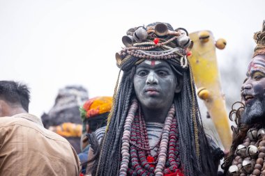 Varanasi, Uttar Pradesh, Hindistan - 20 Mart 2024: Masan Holi, Harishchandra ghat 'ta düzenlenen kutlama sırasında Lord Shiva gibi giyinmiş kuru külle boyanmış yüzlü insanların portresi.