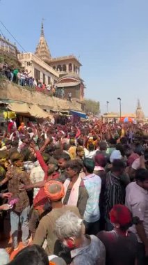 Barsana, Uttar Pradesh, India- March 18 2024: Group of people celebrating the festival of holi on the streets of barsana with herbal colours.